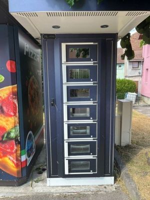 un distributeur automatique installé contre la façade d'un immeuble
