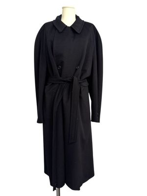 a black coat on a mannequin stand with a white background