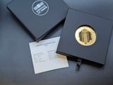 a black box with a gold coin in it on a table
