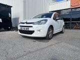 la petite voiture blanche est garée devant un bâtiment
