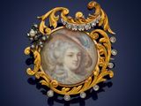 a close up of a gold broochle with a picture of a woman