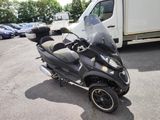 a scooter parked in a parking lot with a truck in the background