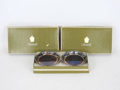 deux paires de lunettes se trouvent dans une boîte posée sur une surface blanche
