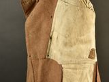 an image of a brown jacket with a tan pocket on a black background