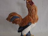 une figurine représentant un coq debout sur un rocher