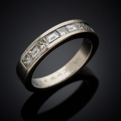a close up view of a wedding ring with princess cut diamonds