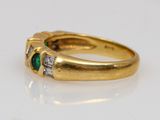 a close up of a gold ring with two emerald stones