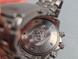 a person holding a watch in their hand on a table