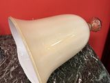 un vase blanc posé sur une table en marbre, avec un mur rouge en arrière-plan