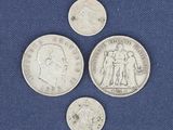 three different types of silver coins on a blue surface