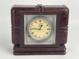 une petite horloge en bois avec des chiffres romains
