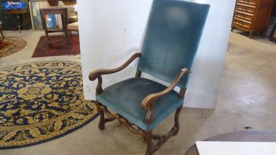 une chaise bleue dans une pièce où il y a un tapis au sol