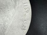 a close up of a silver plate on a black surface