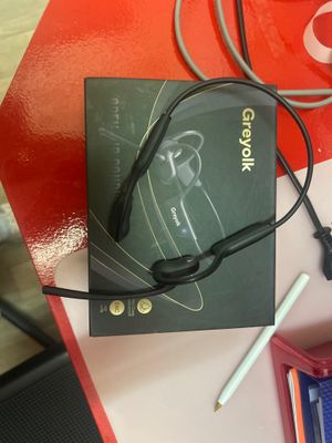 une boîte contenant un casque audio et un stylo, posée sur une table