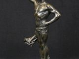 a bronze statue of a man holding a book and pointing to the sky