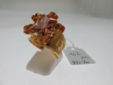 une image représentant une bague en or sertie d'une pierre marron
