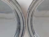 two round mirrors on the wall with a white wall behind them