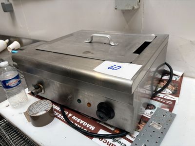 une boîte métallique portant une étiquette, posée sur un comptoir