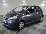 a picture of a small grey car parked in a garage