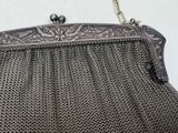 an old metal purse with a chain around it hanging on a wall