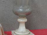 un vase en verre et une paire de chaussures posés sur une table rouge