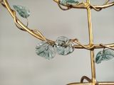 a close up of a gold tree with glass beads on it