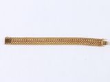 a close up of a gold chain bracelet on a white surface