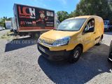 La camionnette jaune est garée sur le parking, à côté d'un camion.
