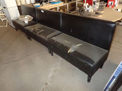 un canapé en cuir noir placé au milieu d'une pièce