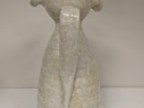 a white vase with a tie on it on a table