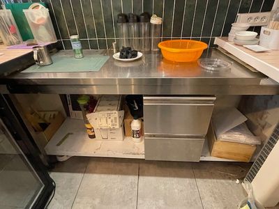 a stainless steel counter in a kitchen with a orange bowl on it