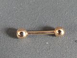 a small gold nose ring with two balls on it