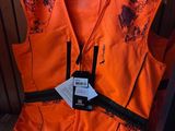 an orange vest with a tag on it sitting on a wooden shelf