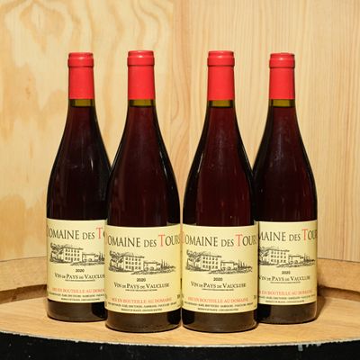 three bottles of wine sit on a wooden barrel with a cork stopper