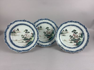 three blue and white plates with flowers and trees on them