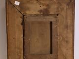 an old wooden picture frame on a white surface with a tag on it