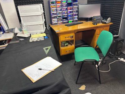 a desk with a computer and a chair in a room