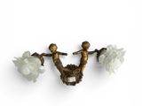 two wall sconces that have angels on them