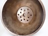 a metal bowl with stars in it on a white surface