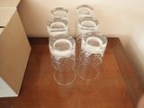 six verres vides posés sur une table à côté d'une boîte en carton