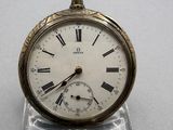 clock with roman numerals on the face of it sitting on a clear stand