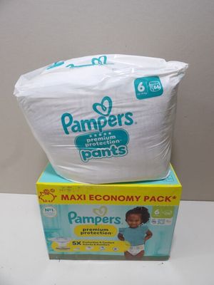 two boxes of diapers sitting on top of each other on a table