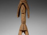 l'image d'une statue en bois représentant un homme avec un chapeau sur la tête