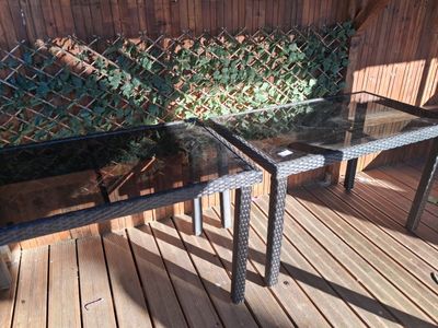 a glass table with a glass top on a wooden deck