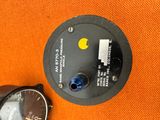 a watch sitting next to a watch on an orange cloth