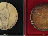 an image of a gold medal with a picture of a dog on it