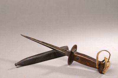 un couteau posé par terre à côté d'une paire de ciseaux