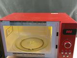 un micro-ondes rouge posé sur une table en bois