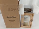 une boîte en carton posée sur une table, avec une bougie à l'intérieur