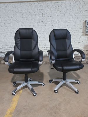 two black leather office chairs sitting next to each other
